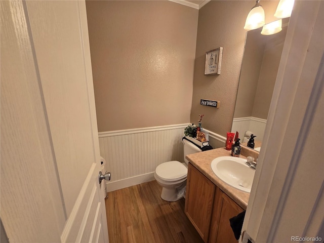 bathroom featuring hardwood / wood-style floors, vanity, toilet, and crown molding