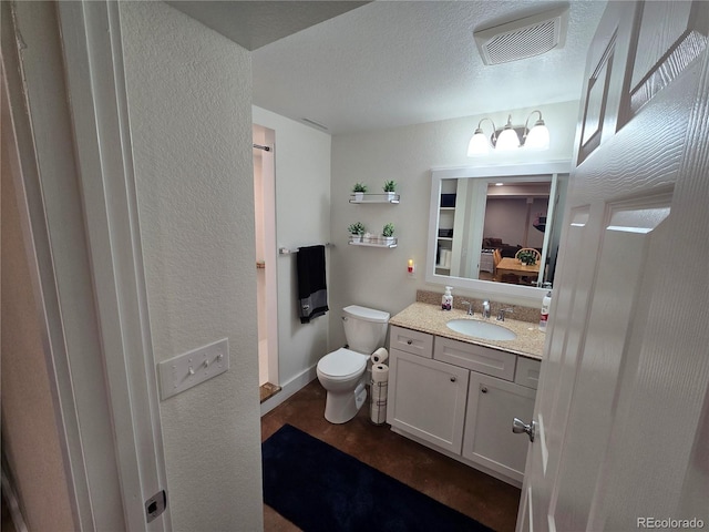 bathroom featuring vanity, a textured ceiling, and toilet