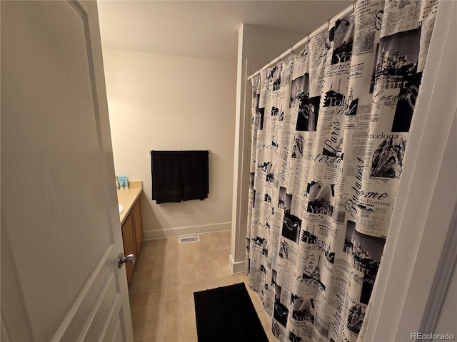 bathroom with curtained shower and vanity