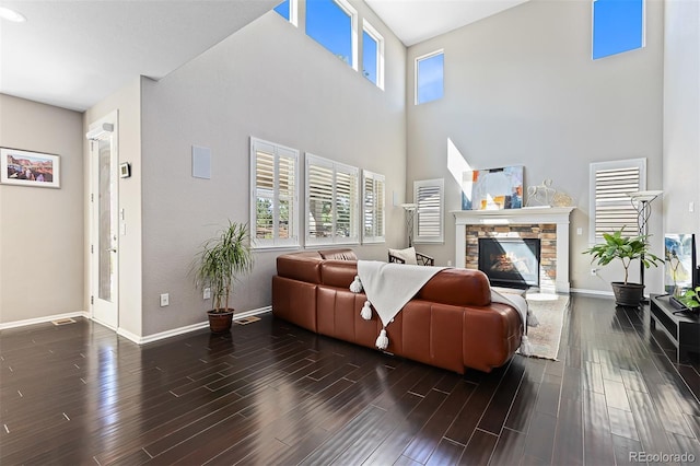 6728 S Catawba Way, Aurora, CO 80016 - living area featuring a towering ceiling, plenty of natural light, a stone fireplace, and wood finished floors