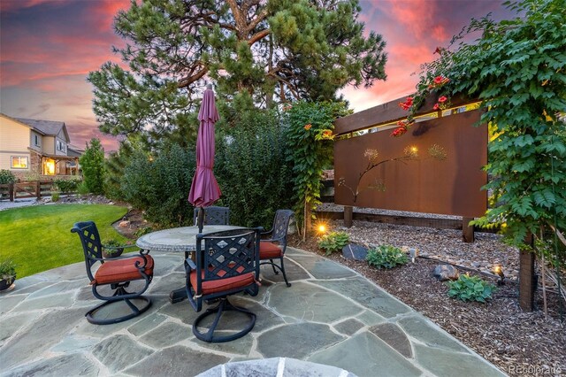 6728 S Catawba Way, Aurora, CO 80016 - patio terrace at dusk with outdoor dining area, a patio area, and a yard