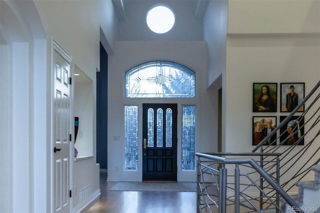 entryway with wood-type flooring and a high ceiling