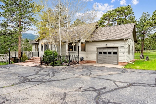 640 Pinewood Ln, Estes Park, CO 80517 - view of front of home with an attached garage, asphalt driveway, a shingled roof, and a mountain view