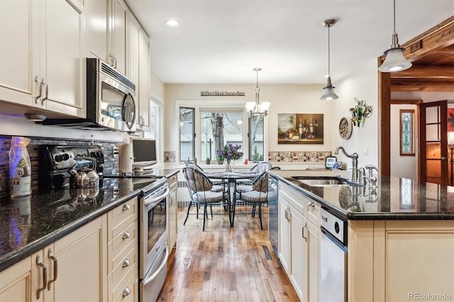 640 Pinewood Ln, Estes Park, CO 80517 - kitchen featuring stainless steel appliances, a sink, light wood-style flooring, decorative light fixtures, and a chandelier