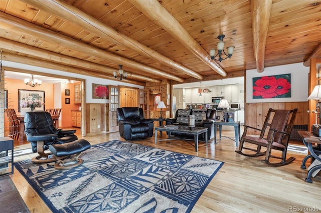 640 Pinewood Ln, Estes Park, CO 80517 - living room featuring a chandelier, light wood-type flooring, wooden walls, wainscoting, and wood ceiling with exposed beams