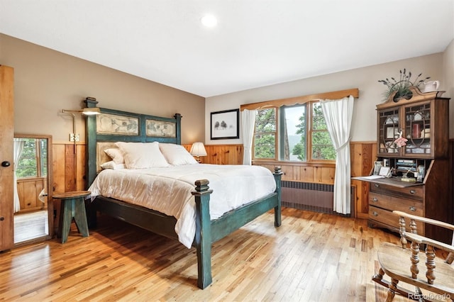 640 Pinewood Ln, Estes Park, CO 80517 - bedroom featuring radiator, light wood-type flooring, a wainscoted wall, and wooden walls