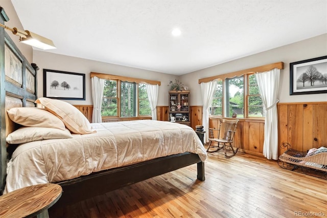 640 Pinewood Ln, Estes Park, CO 80517 - bedroom featuring wainscoting, multiple windows, light wood finished floors, wood walls, and recessed lighting