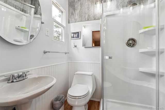 640 Pinewood Ln, Estes Park, CO 80517 - full bathroom featuring a sink, a stall shower, wainscoting, wood finished floors, and toilet