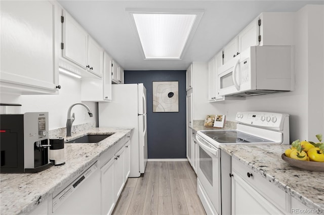 kitchen with sink, white cabinetry, light stone counters, light wood-type flooring, and white appliances