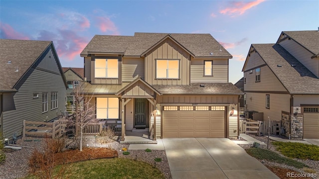 view of front of house featuring driveway, covered porch, fence, an attached garage, and board and batten siding