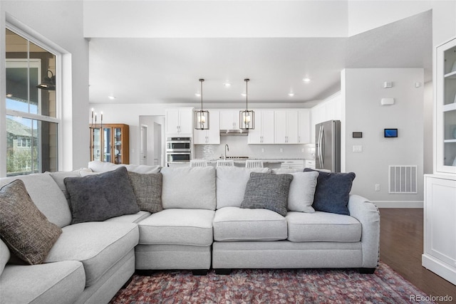 living area with recessed lighting, visible vents, baseboards, and dark wood-style flooring