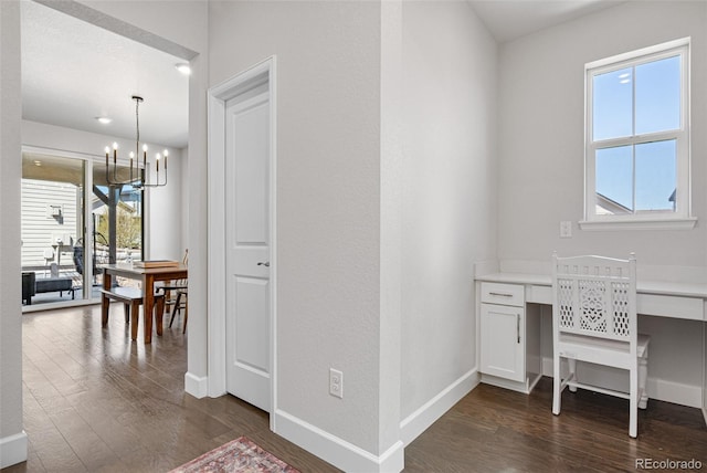 office space featuring baseboards, a notable chandelier, and dark wood-type flooring