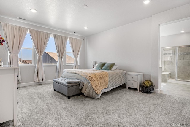 carpeted bedroom featuring ensuite bath, baseboards, multiple windows, and visible vents