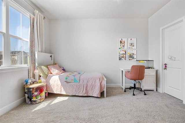 bedroom featuring baseboards, multiple windows, and carpet