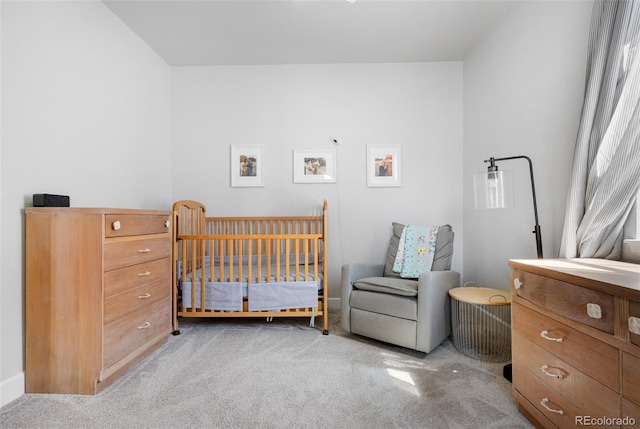 carpeted bedroom featuring a crib