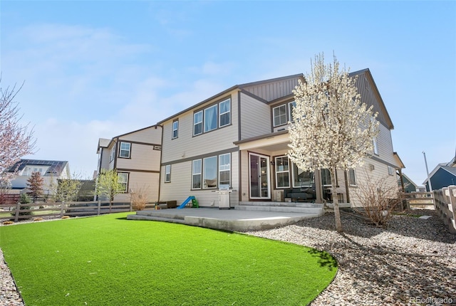 rear view of property with a fenced backyard, a patio area, and a lawn
