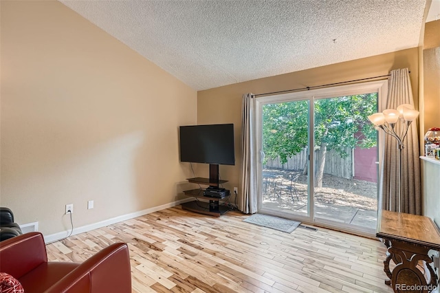 17948 E Colgate Pl, Aurora, CO 80013 - living area featuring vaulted ceiling, a textured ceiling, and wood finished floors
