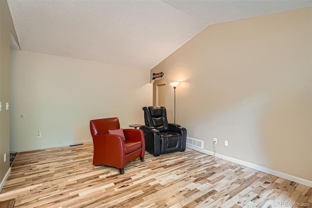 17948 E Colgate Pl, Aurora, CO 80013 - living area with light wood finished floors, lofted ceiling, and a textured ceiling