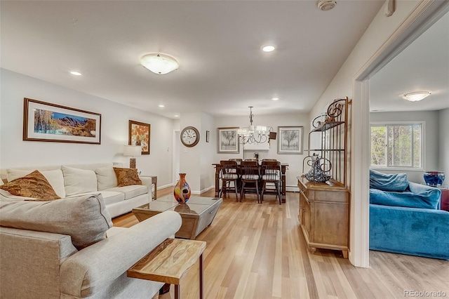 living room featuring light hardwood / wood-style floors and an inviting chandelier