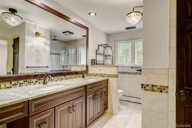 bathroom with tile walls, large vanity, toilet, tile flooring, and baseboard heating