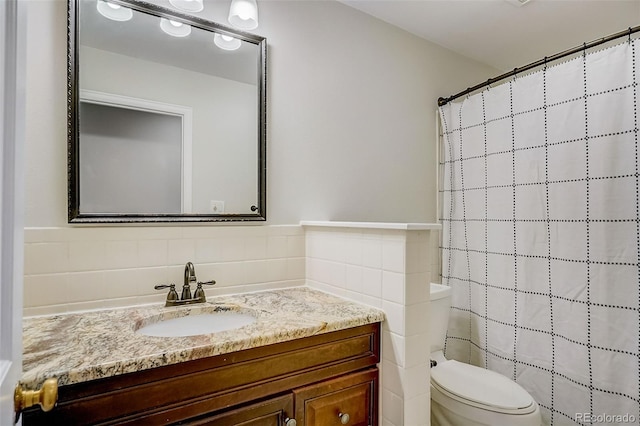 bathroom with oversized vanity, tile walls, backsplash, and toilet