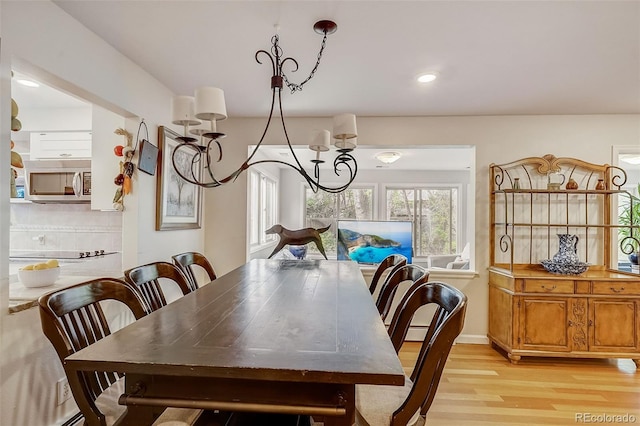 dining area featuring light wood-type flooring and a chandelier