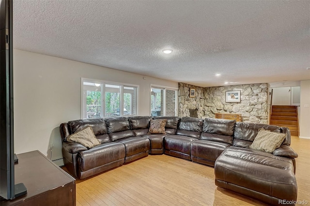 living room with a textured ceiling, light wood-type flooring, and a baseboard radiator