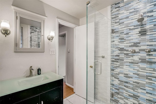 bathroom with walk in shower, vanity with extensive cabinet space, and hardwood / wood-style floors