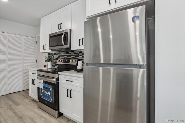 7970 Chase Cir Unit 85, Arvada, CO 80003 - kitchen featuring appliances with stainless steel finishes, backsplash, light wood-style floors, white cabinets, and light countertops