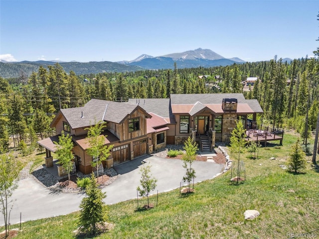 41 Barton Ridge Dr, Breckenridge, CO 80424 - view of front facade featuring a forest view, stone siding, a mountain view, concrete driveway, and a garage