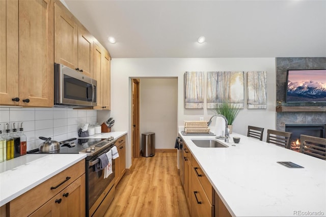41 Barton Ridge Dr, Breckenridge, CO 80424 - kitchen with stainless steel appliances, light wood finished floors, light countertops, decorative backsplash, and a multi sided fireplace
