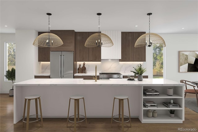 kitchen with a kitchen bar, dark brown cabinets, appliances with stainless steel finishes, and a sink