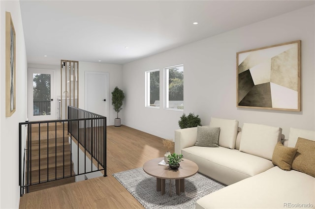 living area with recessed lighting, wood finished floors, and a healthy amount of sunlight