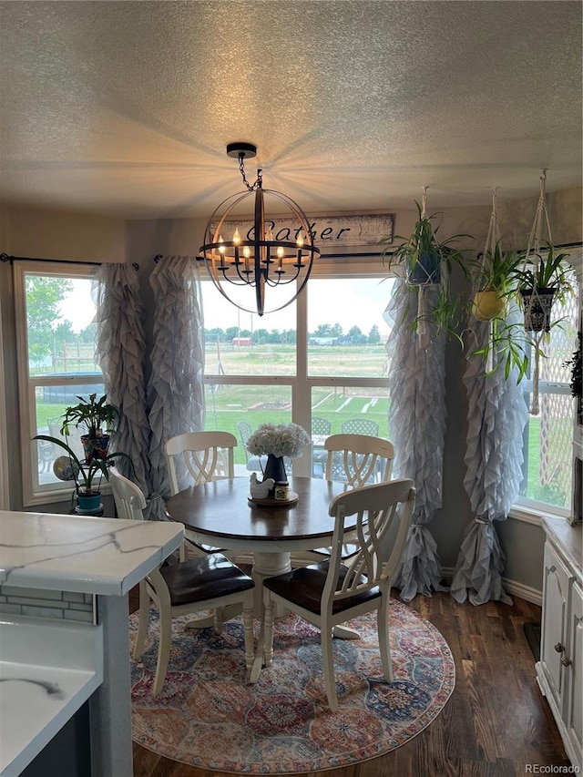825 Cherokee St, Strasburg, CO 80136 - dining space featuring a textured ceiling, a chandelier, and dark wood-style flooring
