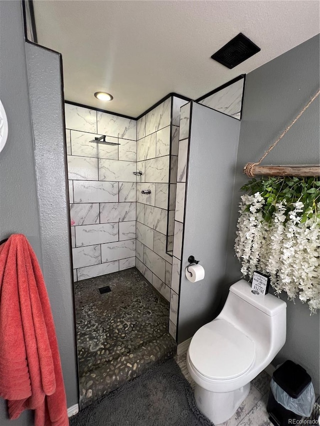 825 Cherokee St, Strasburg, CO 80136 - bathroom featuring tiled shower and toilet