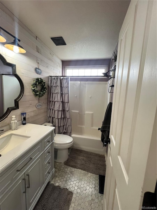 825 Cherokee St, Strasburg, CO 80136 - full bath with wooden walls, vanity, shower / bathtub combination with curtain, tile patterned flooring, and a textured ceiling