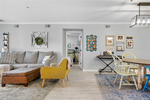 living room featuring crown molding and light hardwood / wood-style flooring