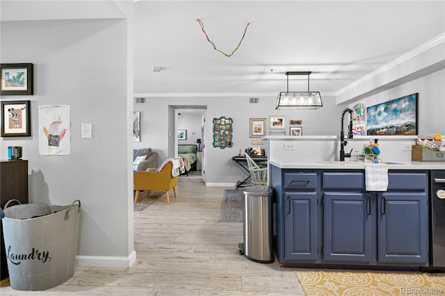 kitchen featuring decorative light fixtures, ornamental molding, light hardwood / wood-style floors, and sink