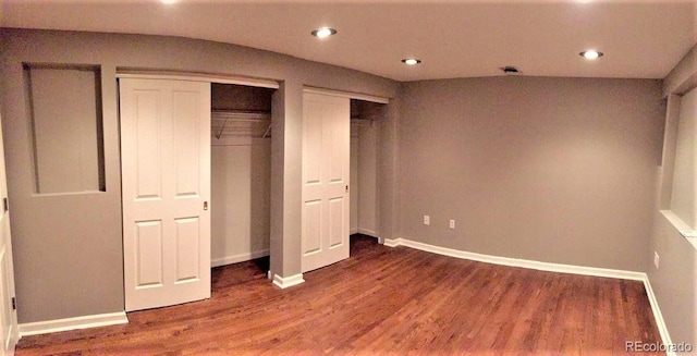 1555 California St Unit 302, Denver, CO 80202 - unfurnished bedroom featuring wood finished floors, multiple closets, and recessed lighting