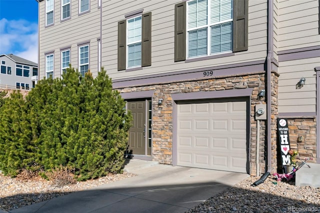 exterior space featuring stone siding, driveway, and an attached garage