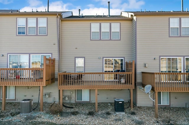 rear view of property featuring central AC unit and a wooden deck