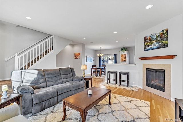 living room with stairs, recessed lighting, light wood-style flooring, and a notable chandelier