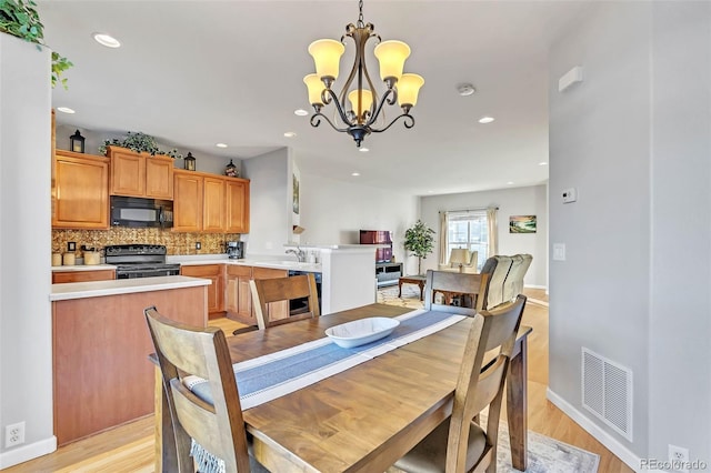 dining room with light wood-style flooring, visible vents, a chandelier, and recessed lighting