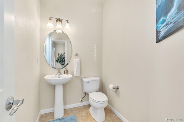 bathroom with baseboards, toilet, and tile patterned floors