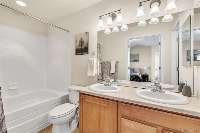 full bathroom featuring connected bathroom, a sink, toilet, and double vanity