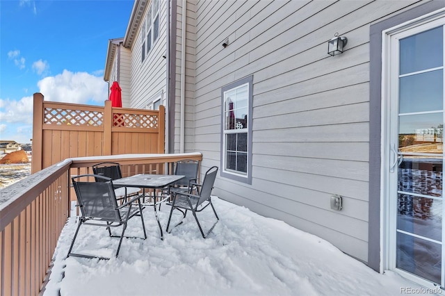 snow covered deck with outdoor dining area