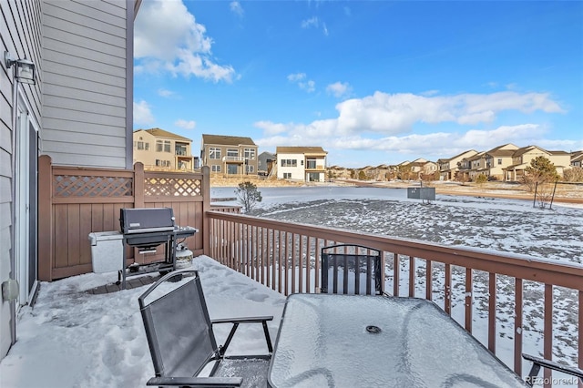 snow covered back of property with a residential view and area for grilling