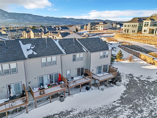 snow covered property featuring a mountain view and a residential view