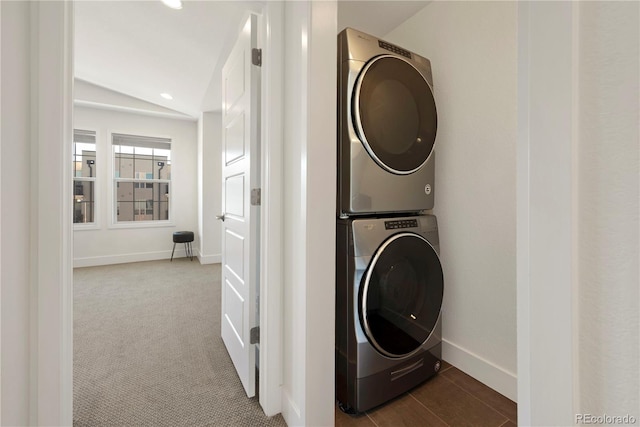 clothes washing area with carpet floors and stacked washer and dryer