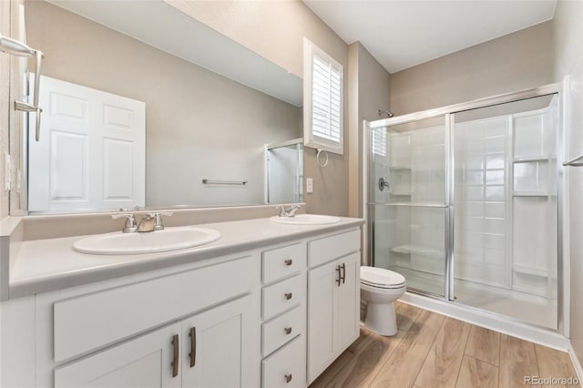 15525 Quince Cir, Thornton, CO 80602 - full bathroom featuring a shower stall, toilet, wood finished floors, and double vanity